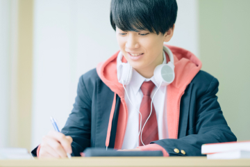 音楽を聴きながら勉強する男子学生